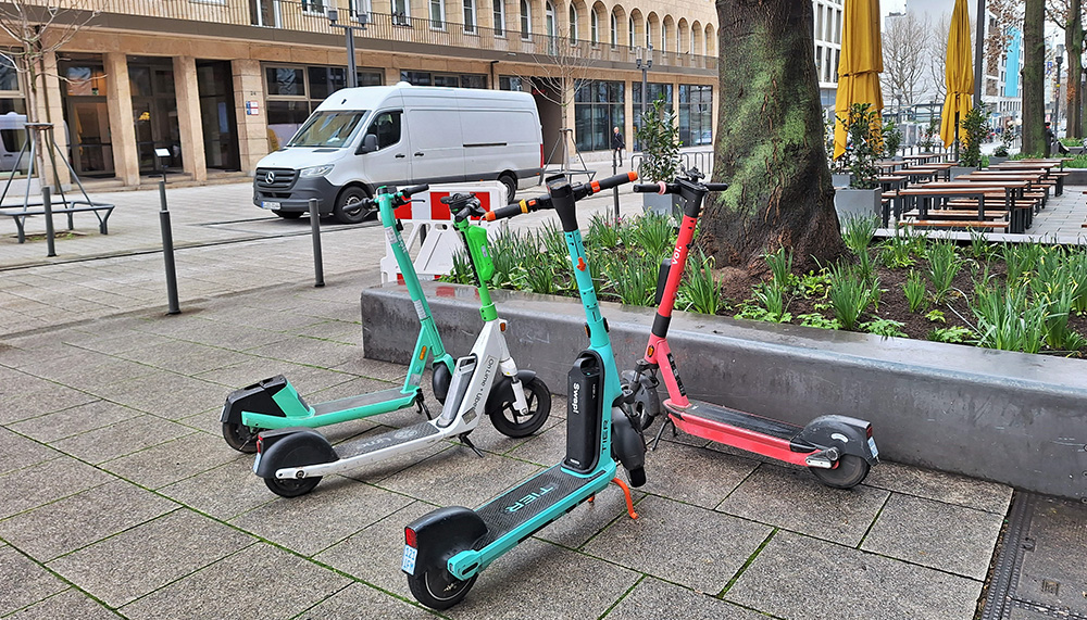Vier freie E-Scooter stehen in der Stadt bereit.